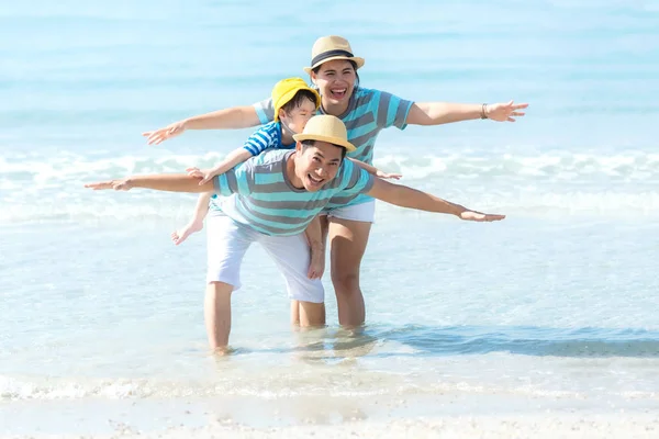 Asian happy family have fun fly on the beach for leisure and destination.  Family people tourism travel enjoy in summer and holiday.  Travel and Family Concep