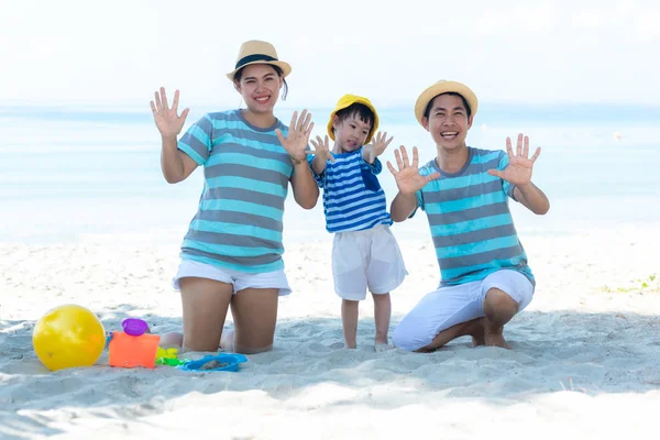 Asian happy family have fun and play yellow ball on the beach.  Family people tourism travel in summer and holiday  for leisure and destination. Travel and Family Concept