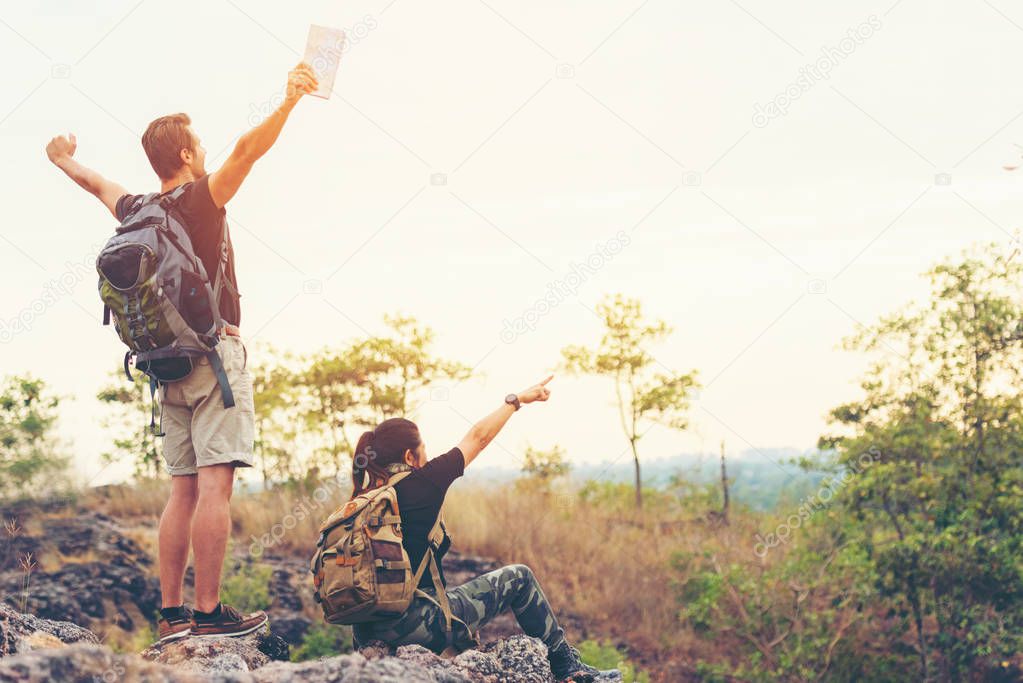 Hiker couple backpack enjoy happy and sitting happy feeling freedom good and strong weight victorious facing on the natural mountain. Traveler going camping outdoors destination leisure