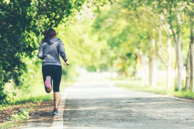 Sportif asya kadın koşucu çalışan ve yolda koşu. Bir Parkta Açık Egzersiz. Kilo Kaybı ve Sağlıklı Kavram