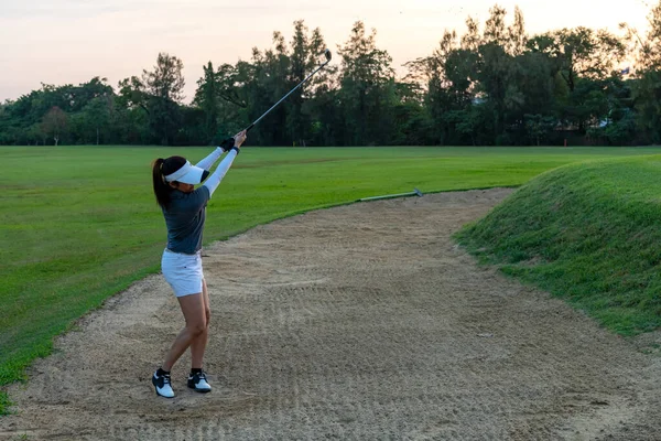 ゴルファースポーツコースゴルフボールフェアウェイ 人々のライフスタイルの女性は ゲームゴルフをプレイし 砂のトラップの外に打つ緑の芝生の上に行く アジア女子プレーヤーゲーム夏に撮影 — ストック写真