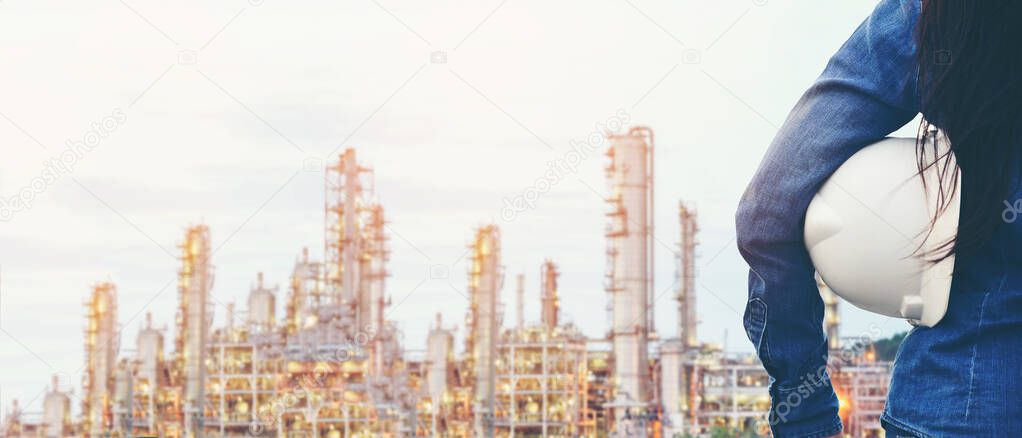 Engineer inspector construction building power plant energy industry in project site.  Close up hand woman worker holding white helmet for security control refinery plant.   Industry and Engineer Concept, copy space and banner