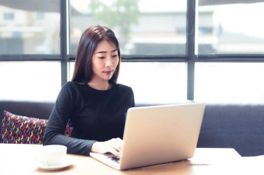 Gençler evde dizüstü bilgisayarla çalışır ve sabahları kahve içerler. Evde dinlenirler. Asyalı kadın toplantı konferansı ofisi internet üzerinden bağlıyor. İş ve Teknoloji Konsepti