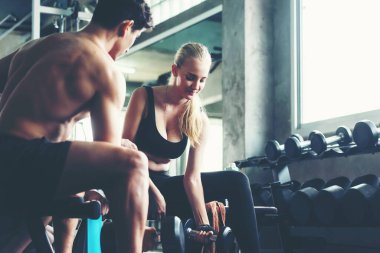 Spor salonunda erkek ve kadınla beden sağlığı ve zayıflığı eğitimi egzersizi. Beden eğitimi eğitmeni müşterileriyle spor yapıyor. Diyet ve Sağlıklı Spor Konsepti