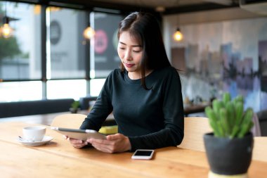 Gençler evde dizüstü bilgisayarla çalışır ve sabahları kahve içerler. Evde dinlenirler. Asyalı kadın toplantı konferansı ofisi internet üzerinden bağlıyor. İş ve Teknoloji Konsepti