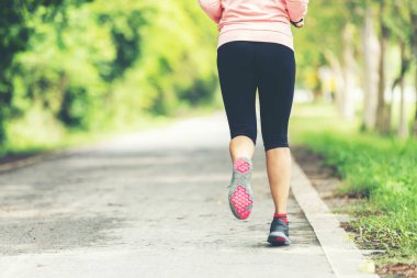 Sağlıklı bir kadın dışarıda koşuyor ve antrenman yapıyor. Asyalı koşucular spor salonu, spor salonu, doğa parkı geçmişi. Sağlıklı ve Yaşam Tarzı Konsepti.