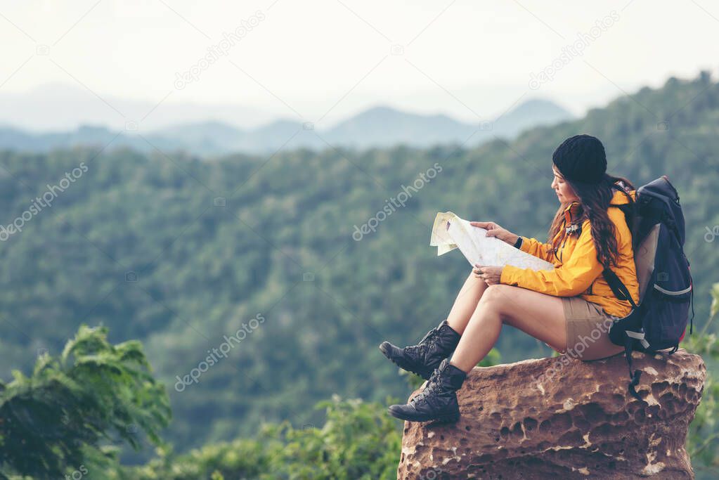 Woman travel hiker adventure on mountain nature landscape. Asia people lifestyle tourist girl backpack sitting with map to find directions explore and camping outdoors for relax summer time.