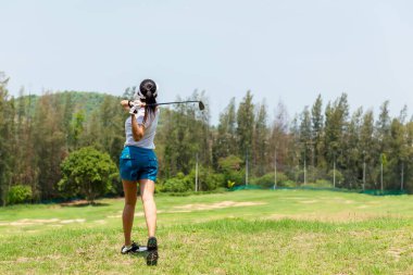 Golf sahası golf sahası sahası. Yeşil çimlerin üzerinde golf oynayan insanların yaşam tarzı. Asya 'lı bayan oyuncu yazın vuruldu. Sağlıklı ve açık hava sporu