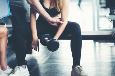 Spor salonunda erkek ve kadınla beden sağlığı ve zayıflığı eğitimi egzersizi. Beden eğitimi eğitmeni müşterileriyle spor yapıyor. Diyet ve Sağlıklı Spor Konsepti