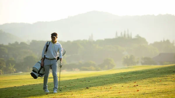 高尔夫球手亚洲人走在球道上 球袋在阳光下 球杆在球道上 业余爱好在假日和假期 贪婪俱乐部高尔夫背景 生活方式及运动概念 — 图库照片