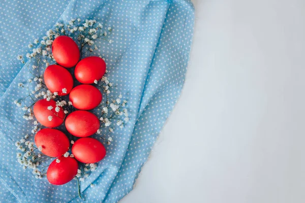 Mavi arka planda boyanmış Paskalya yumurtaları. bahar arkaplanı çiçekler ve yumurtalar üst görünüm düz yatıyordu