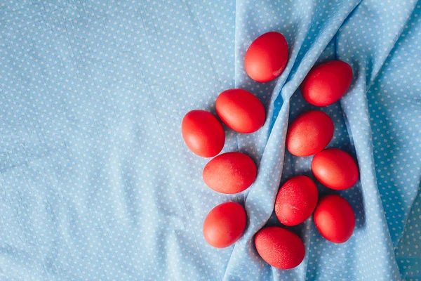 Mavi arka planda boyanmış Paskalya yumurtaları. bahar arkaplanı çiçekler ve yumurtalar üst görünüm düz yatıyordu