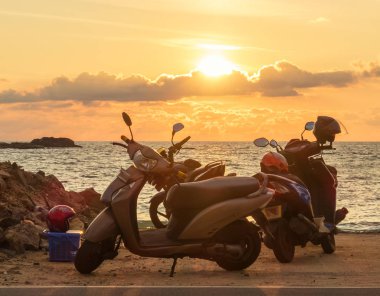 Gün batımında Hint Okyanusu kıyısında scooterlar, Hikkaduwa, Sri Lanka