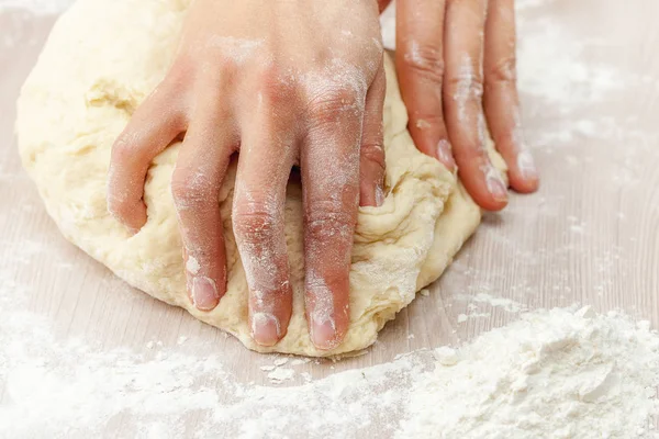 Fingers knead holiday dough on a flour-sprinkled table, Russia — Stock Photo, Image