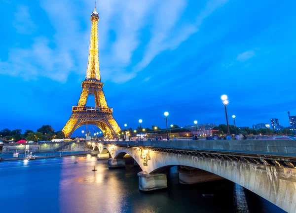 Torre Eiffel iluminada por la noche y la gente —  Fotos de Stock