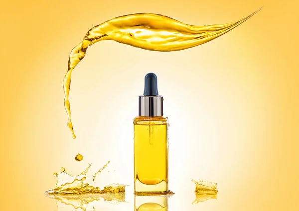 La botella del aceite cosmético amarillo con gran salpicadura por encima y muchas salpicaduras alrededor Imagen de stock