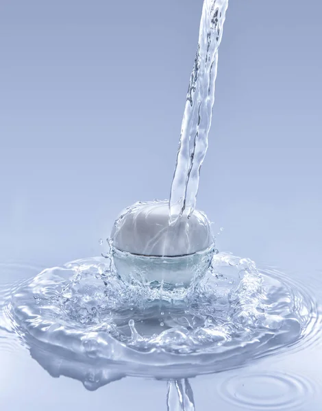 El frasco de crema hidratante en el gran chorro de agua azul Imágenes de stock libres de derechos