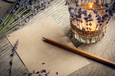 Boş bir kağıt yaprağına, kalem ve parlak mum şamdan