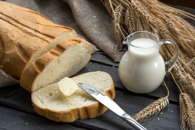Fırından yeni çıkmış beyaz ekmek spikelets buğday, süt ve tereyağı ile 