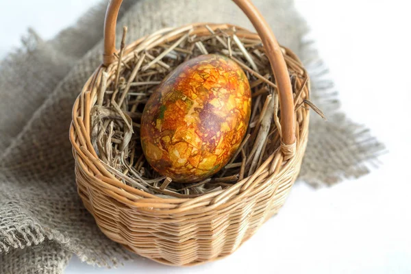 Colorful egg in a wicker basket, easter background — Stock Photo, Image