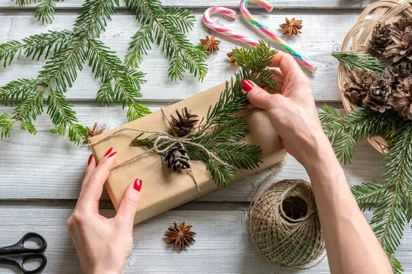 Woman hands decorating gift box in Christmas style. View from ab — Stock Photo, Image