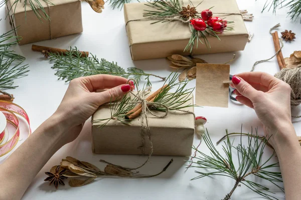 Vista superior nas mãos da mulher decorando caixas de presente com cartão vazio para texto — Fotografia de Stock