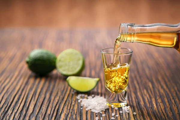 Derramando tequila de ouro tiro com limão — Fotografia de Stock