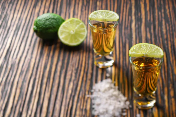 Dva shot zlatá Tequila na hnědé dřevěné pozadí selectiv — Stock fotografie
