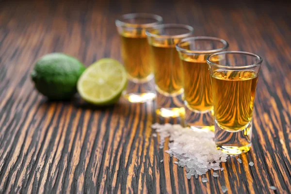 Óculos de tequila de ouro com limão verde, foco seletivo — Fotografia de Stock