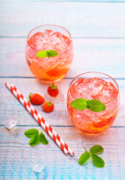 Two glasses of strawberry lemonades on wooden table