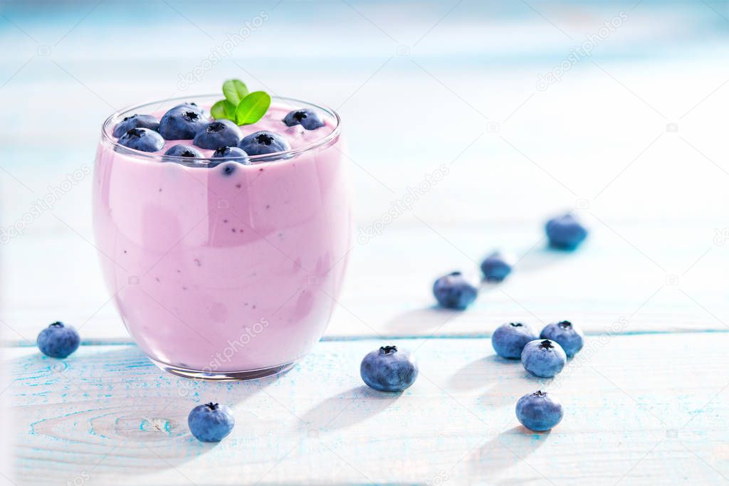 Blueberry smoothie in a glass on a rustic table