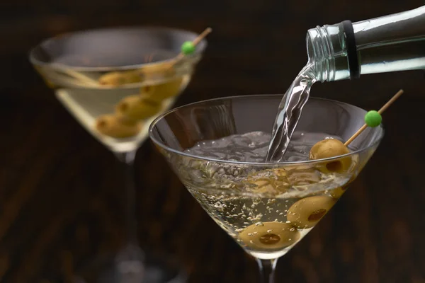 Lití martini z láhve do sklenice proti dřevěnému b — Stock fotografie