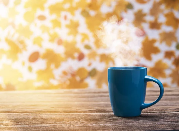 Xícara de café quente em um fundo de folhas de outono — Fotografia de Stock