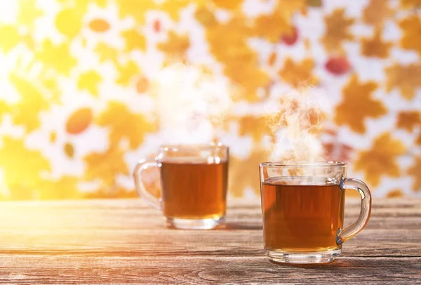 Two glass cup on a wooden board on a autumn background — Stock Photo, Image