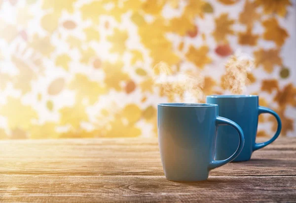 Duas xícaras de xícara de café quente em um fundo folhas de outono — Fotografia de Stock