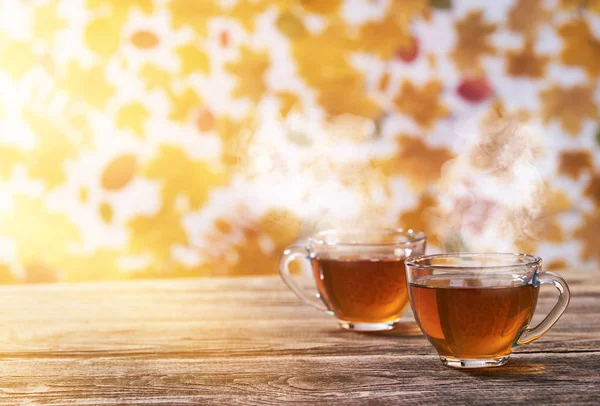 Podzimní kompozice s horkým čajem. Dva skleněný šálek čaje na dřevěné b — Stock fotografie