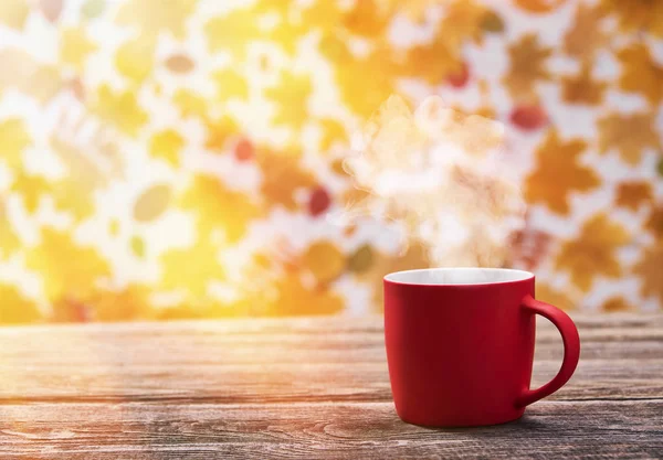 Horký šálek kávy na podzim opustí pozadí. Červený hrnek na kávu. — Stock fotografie