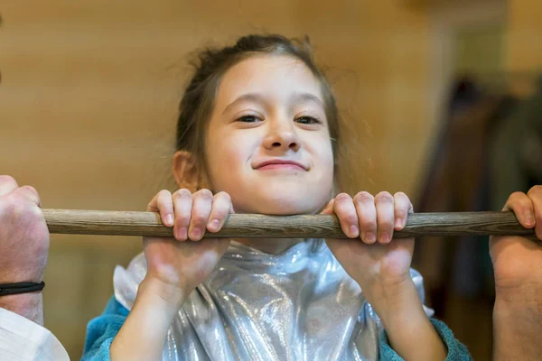 Kleines Mädchen zieht sich an hölzerner Querstange hoch — Stockfoto