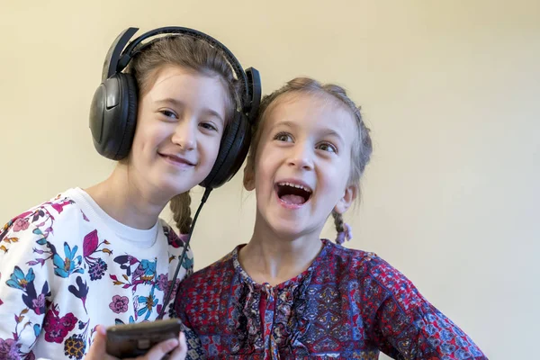 Dwie małe dziewczynki szczęśliwi razem, słuchanie muzyki — Zdjęcie stockowe