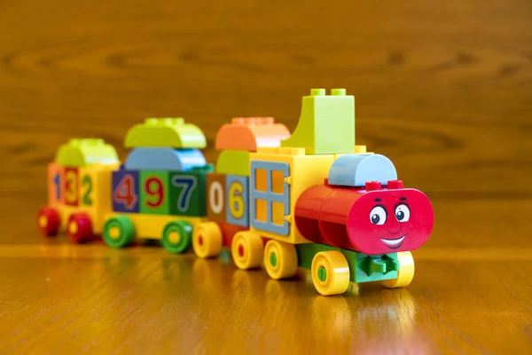 Locomotora infantil con vagones, sobre fondo de madera . — Foto de Stock