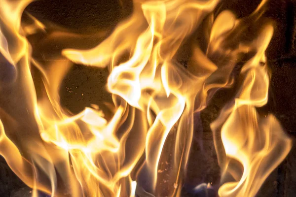Fuego rojo amarillo en la chimenea de cerca. llamas. Fondo de fuego — Foto de Stock