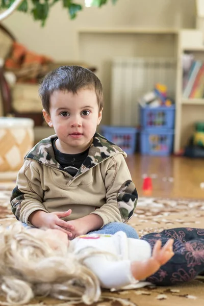 Мальчик 2 лет, играющий в большой дол в игровой комнате — стоковое фото