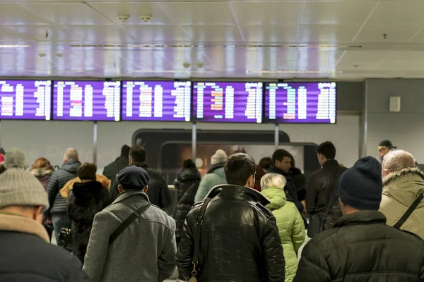 İnsanlar havaalanında uçuş varış için bekliyor. Seçilen odak