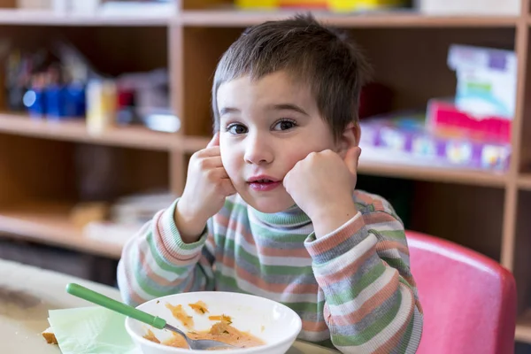 Хлопчик у віці 5 років їсть суп у дитячому садку . — стокове фото