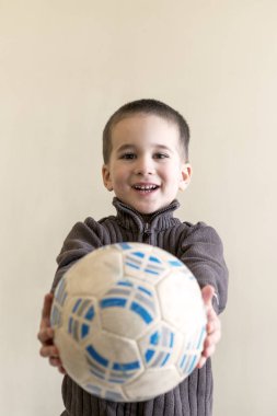 Neşeli çocuk elinde bir futbol topu. Açık renkli. Avrupa görünüm