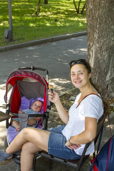 Женщина средних лет гуляет в весеннем парке с новорожденным ребенком . — стоковое фото