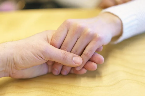 Bir erkek eli bir kadının elini tutar. Sevgi, bakım ve dostluk tezahürü — Stok fotoğraf