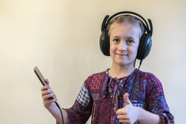 Cuffie bambina utilizzando il telefono. pollice in su — Foto Stock