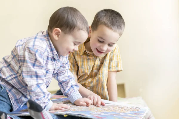 Dos hermanitos leyeron un libro para niños. Amistad de los niños, educación divertida —  Fotos de Stock
