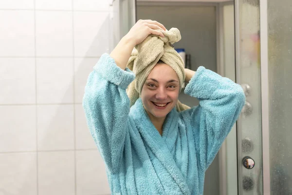 Счастливая женщина после спа извиваясь волосы в полотенце — стоковое фото